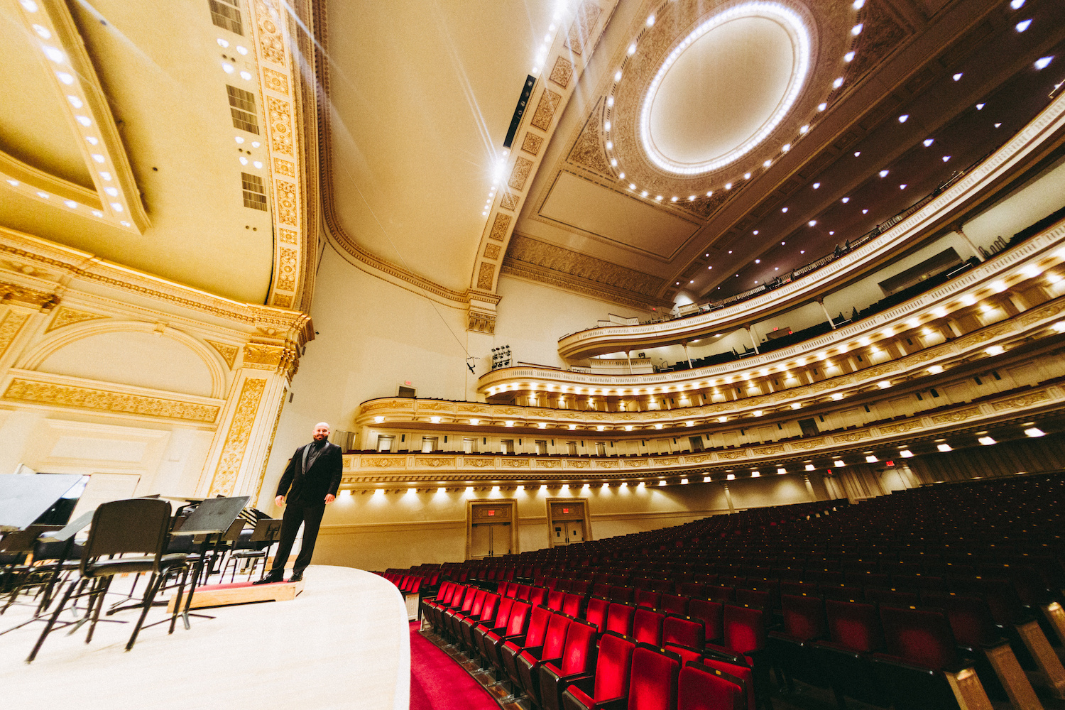 WE.LSU.CARNEGIE.GioOnstage – The La Sierra University Wind Ensemble Director Giovanni Santos pauses for a photo on the Isaac Stern Auditorium/Ronald O. Perelman Stage at Carnegie Hall.
