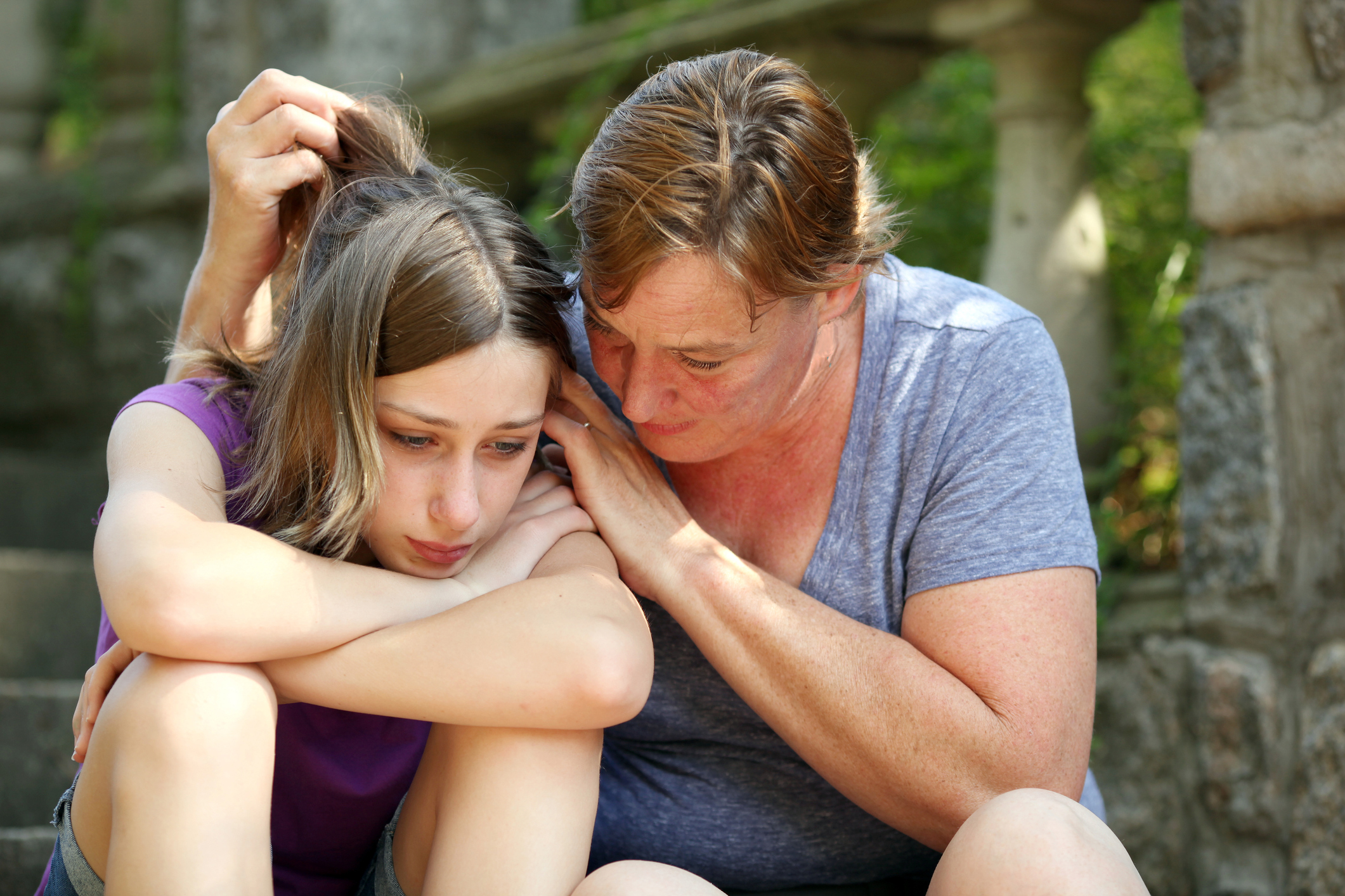 mom comforts teen daughter