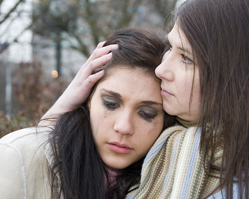 mother comforts crying teen daughter