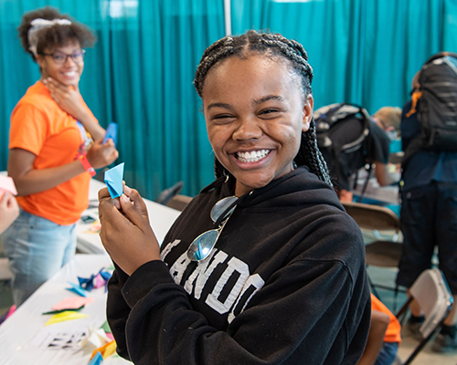 2019 Oshkosh girls in hangar fold paper into origami