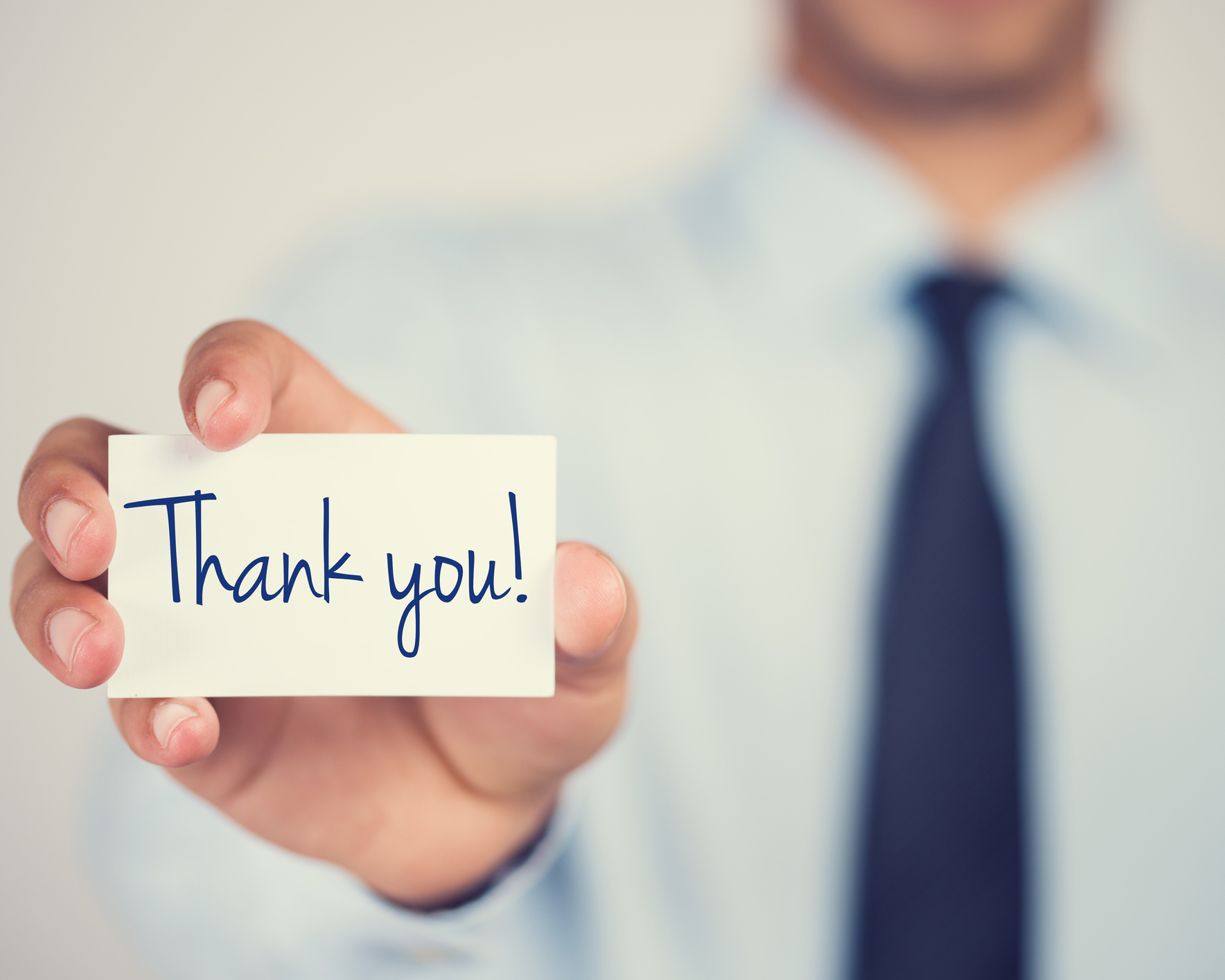 stock photo of man holding thank you card