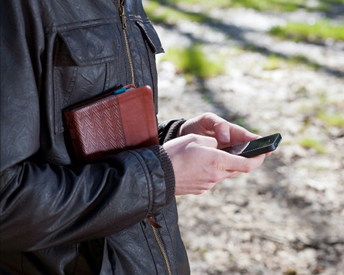 Man holding bible and cell phone