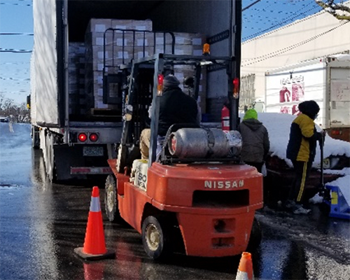 Forklift with truck filled with packages