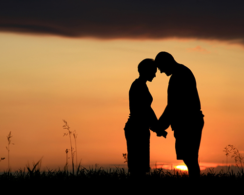 stock photo of couple holding hands at sunset