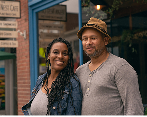 Smiling couple standing in front of  a store