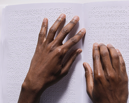 Brown hands reading braille