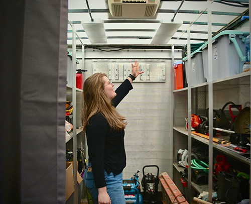 A young woman standing inside a trailer surrounded by tools. The trailer houses the Walla Walla Tool Library.