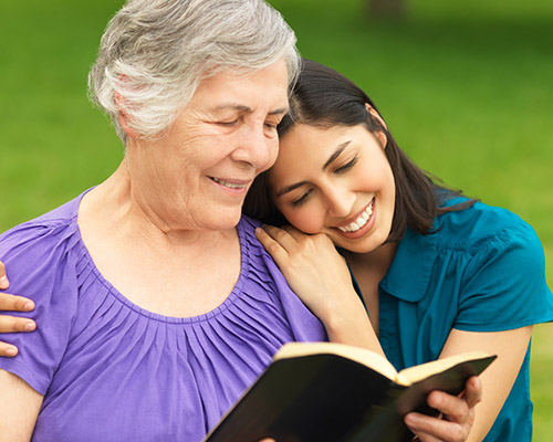 stock photo of elderly woman and daughter studying Bible