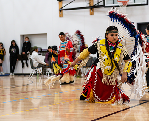 Young Indigenous girl dancing in colourful regalia