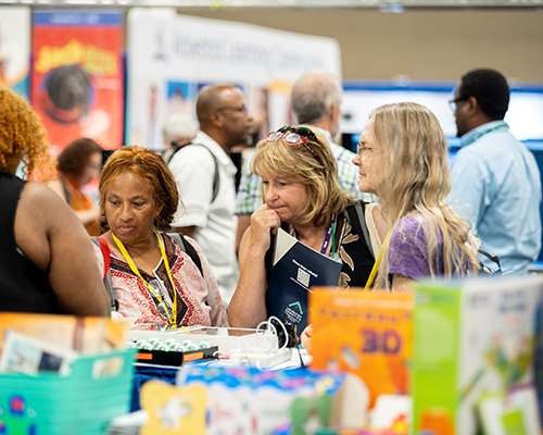 Three women looking at a blurred-out table of science games