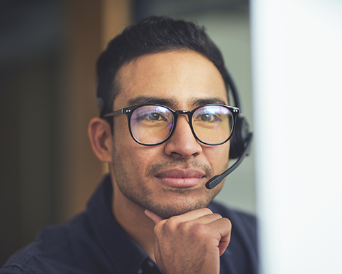 Asian man wearing a headset comprised of a microphone and headphone.