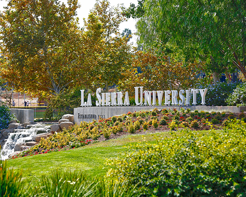 Photo of a hill with block letters on it reading "La Sierra University"