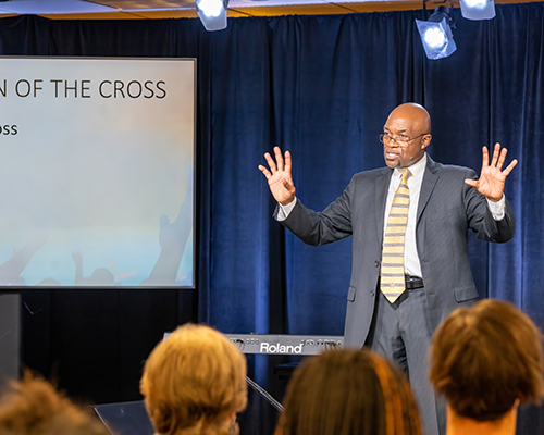 Black man standing in front of a crowd, preaching