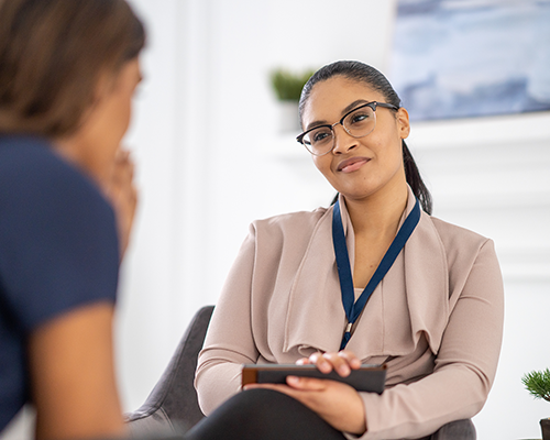 College advisor with a clipboard in hand sits across from student. Advisor is in focus and student is blurred. Photo: Getty Images