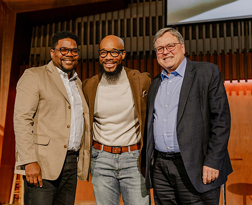 Three men, two black and one white, pose for a picture together in a church setting