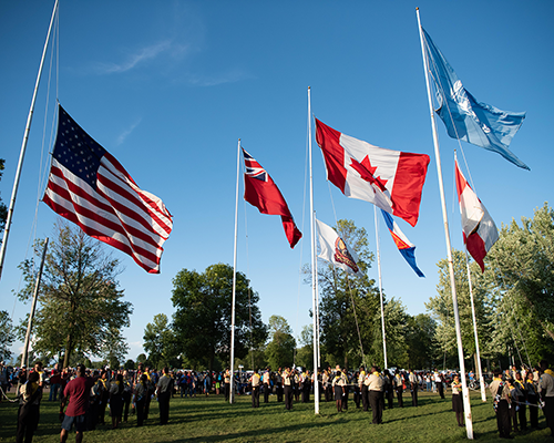 People putting up flags from different countries on a campground