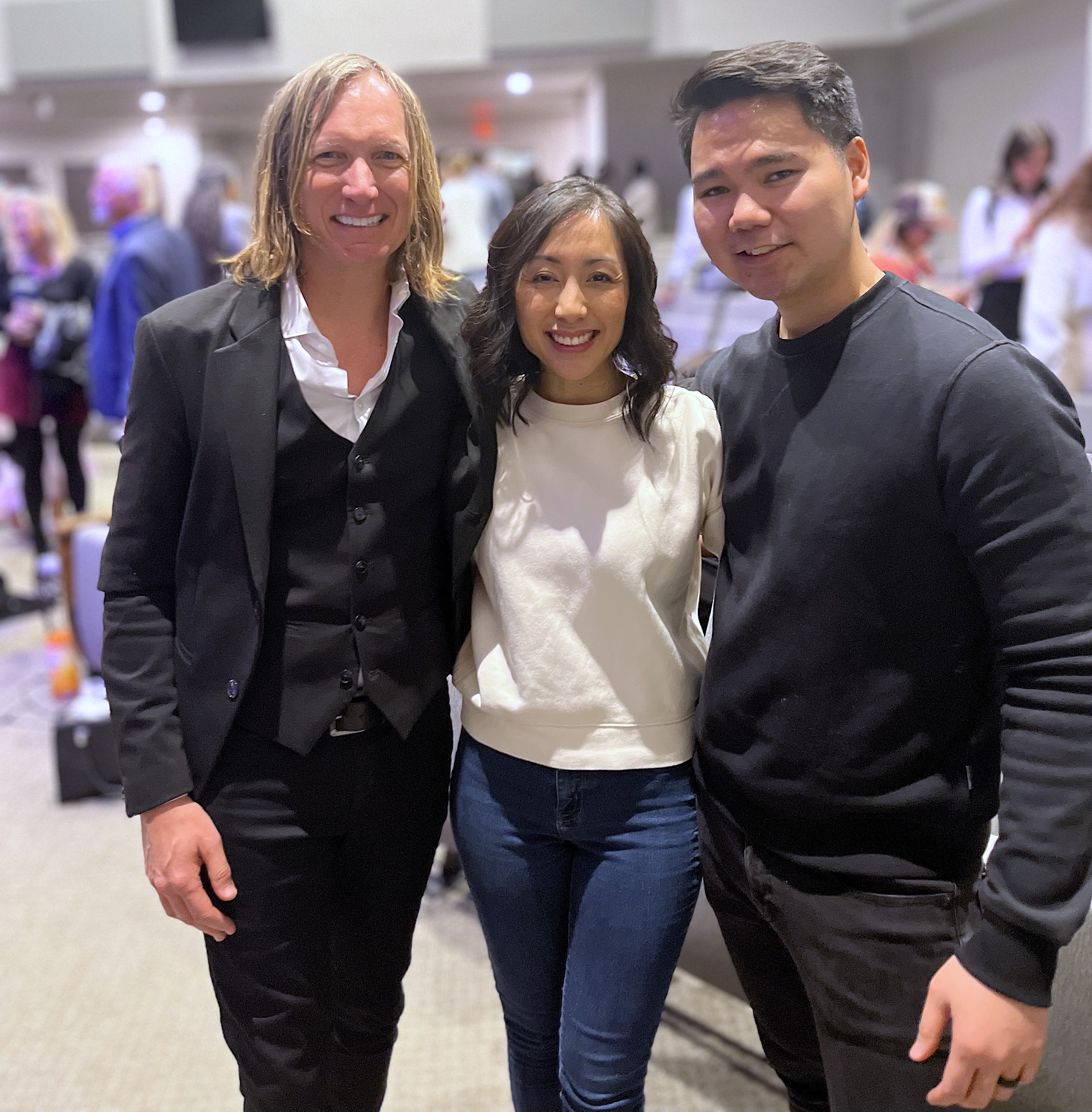 Two men and a woman in the middle, smiling