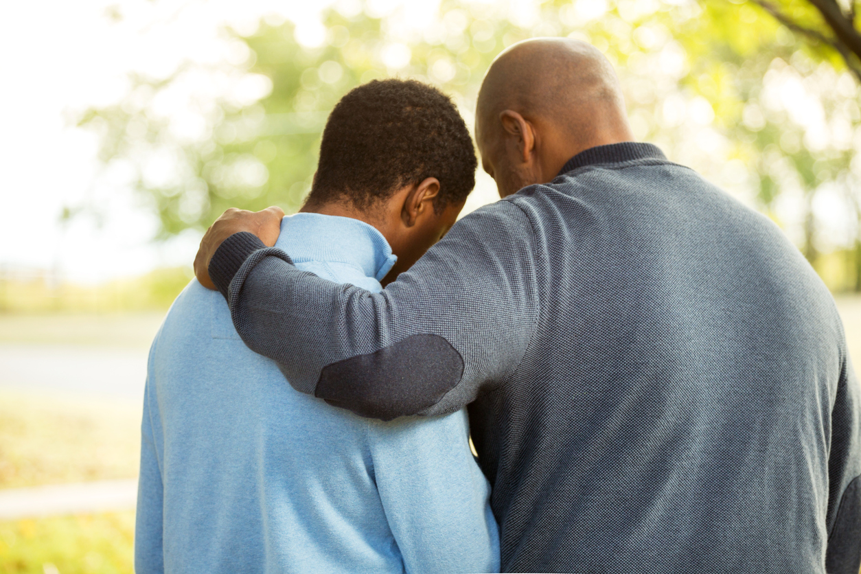 stock photo of father and son in comfort/prayer pose