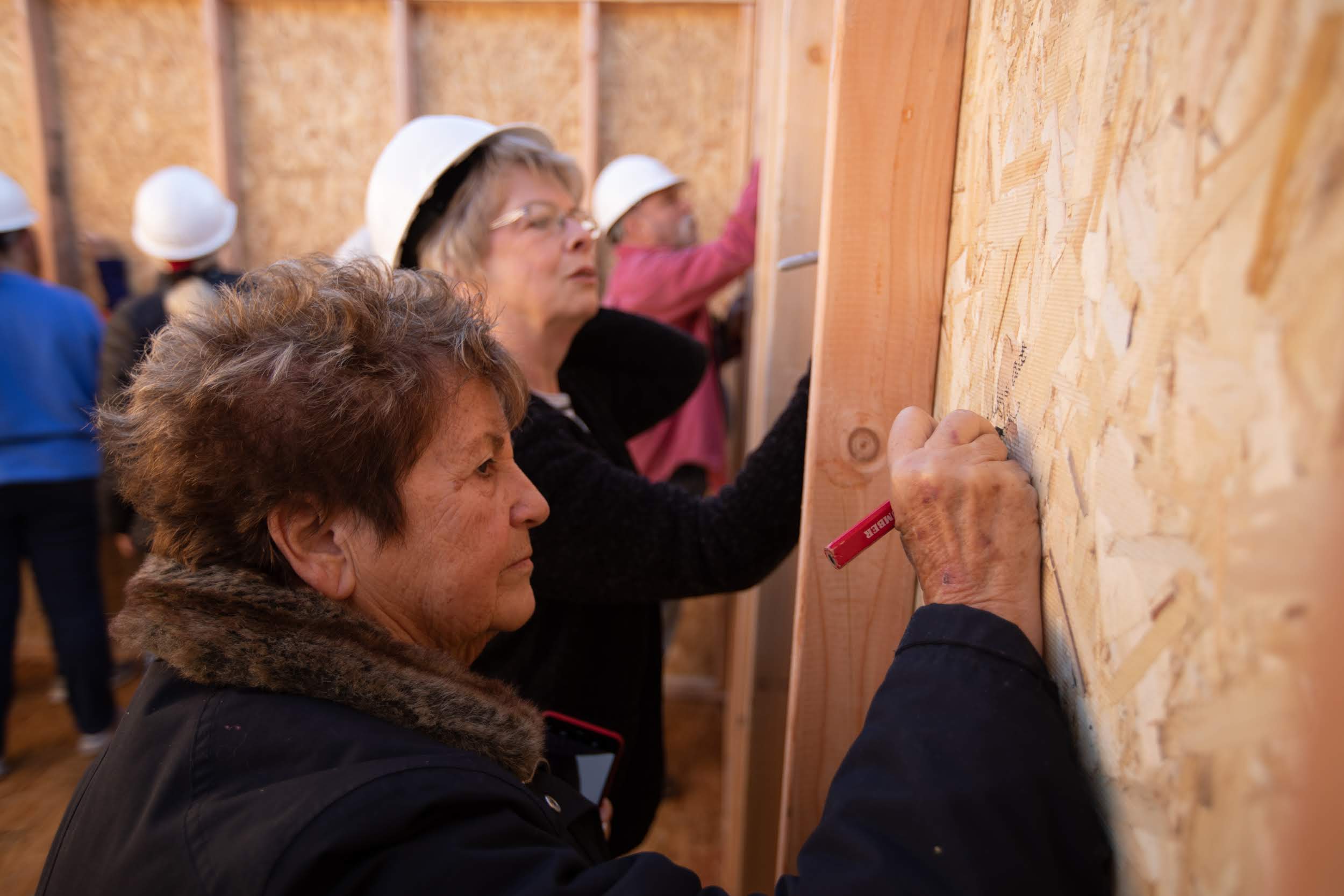 Love Paradise volunteers sign the final shed's inside wall. Photo by Tom Lloyd