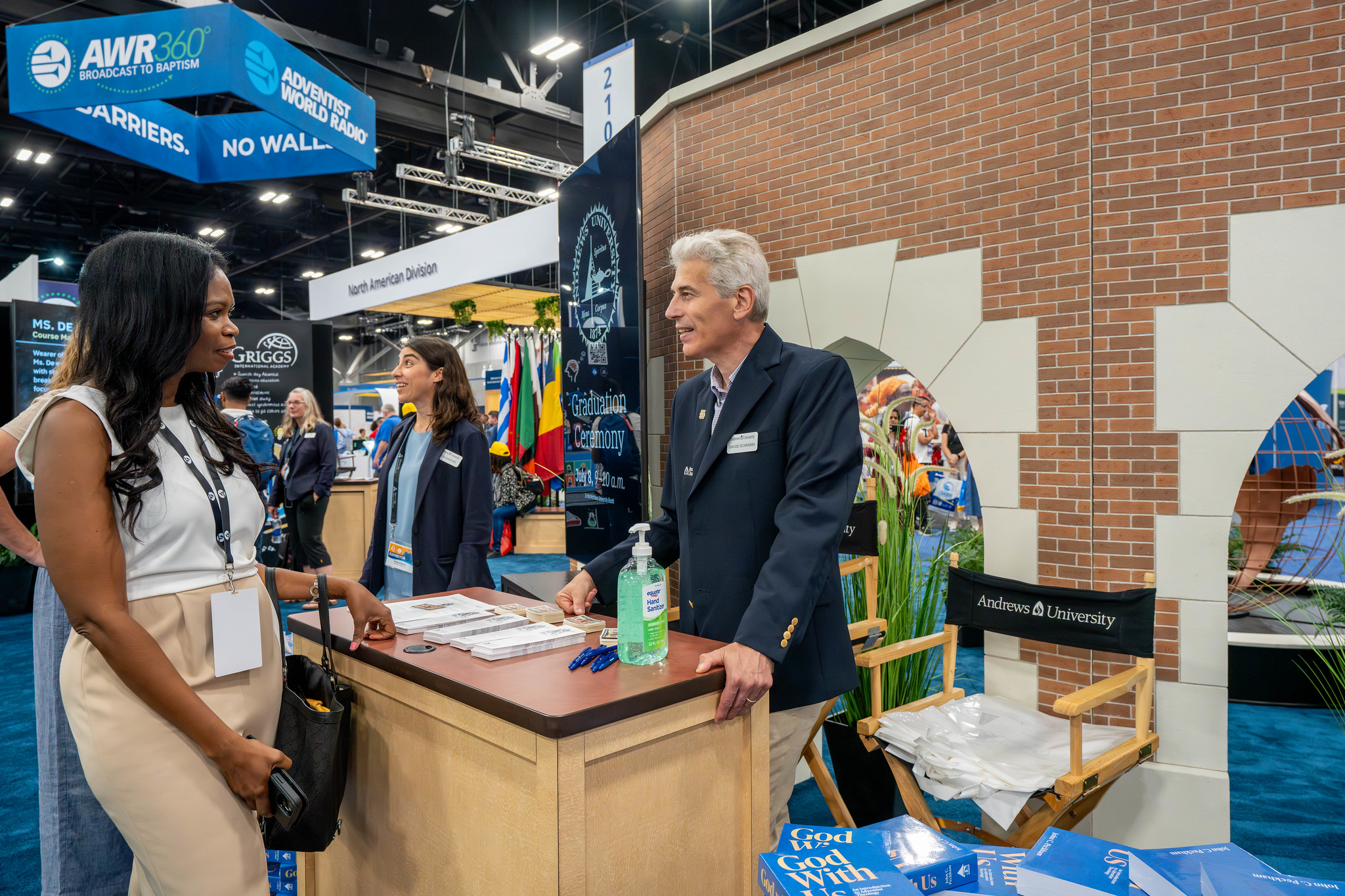 Reporter Herma Percy talks to a representative from Andrews University at the education exhibit.