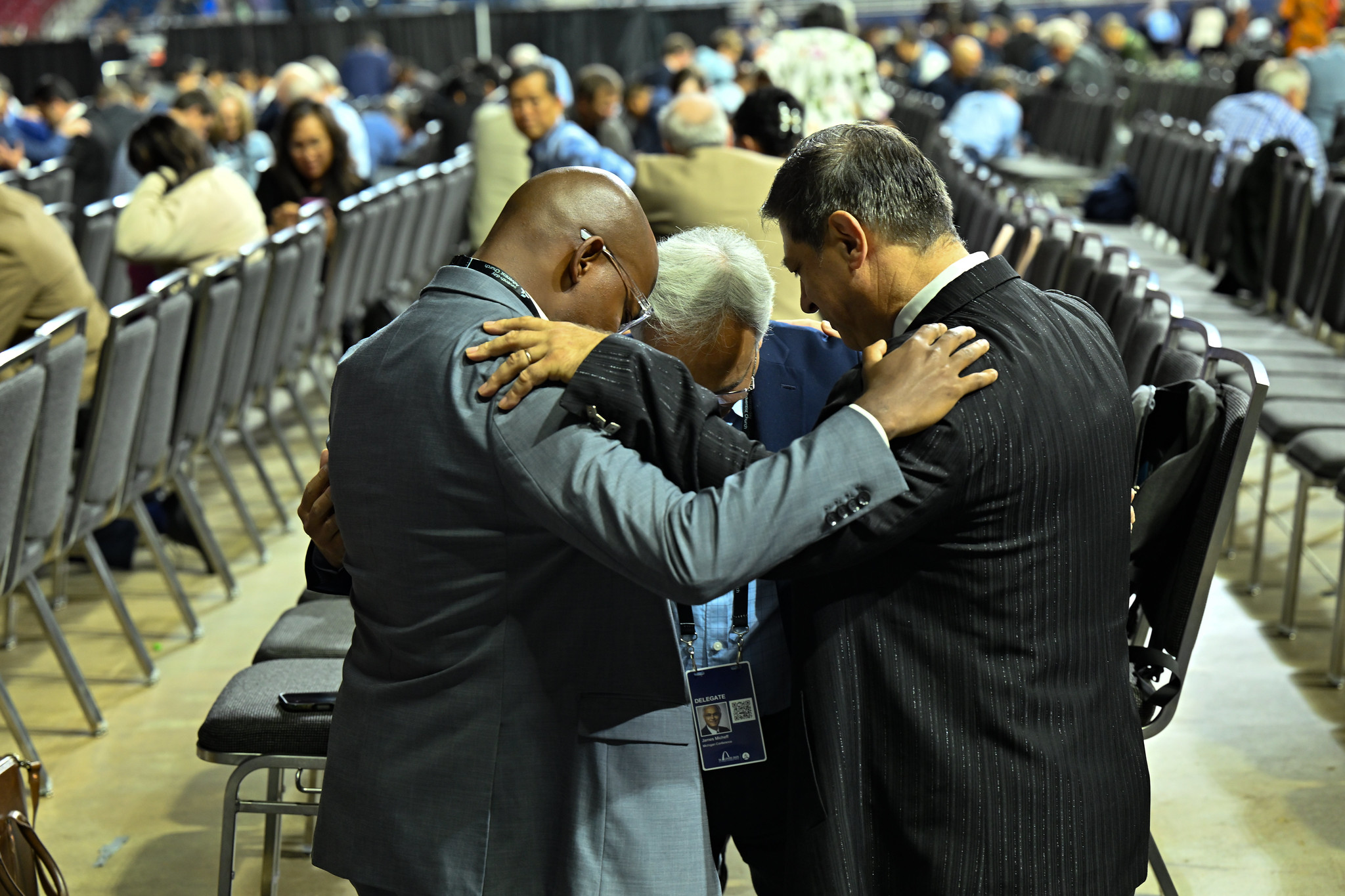 Three men kneel and pray together
