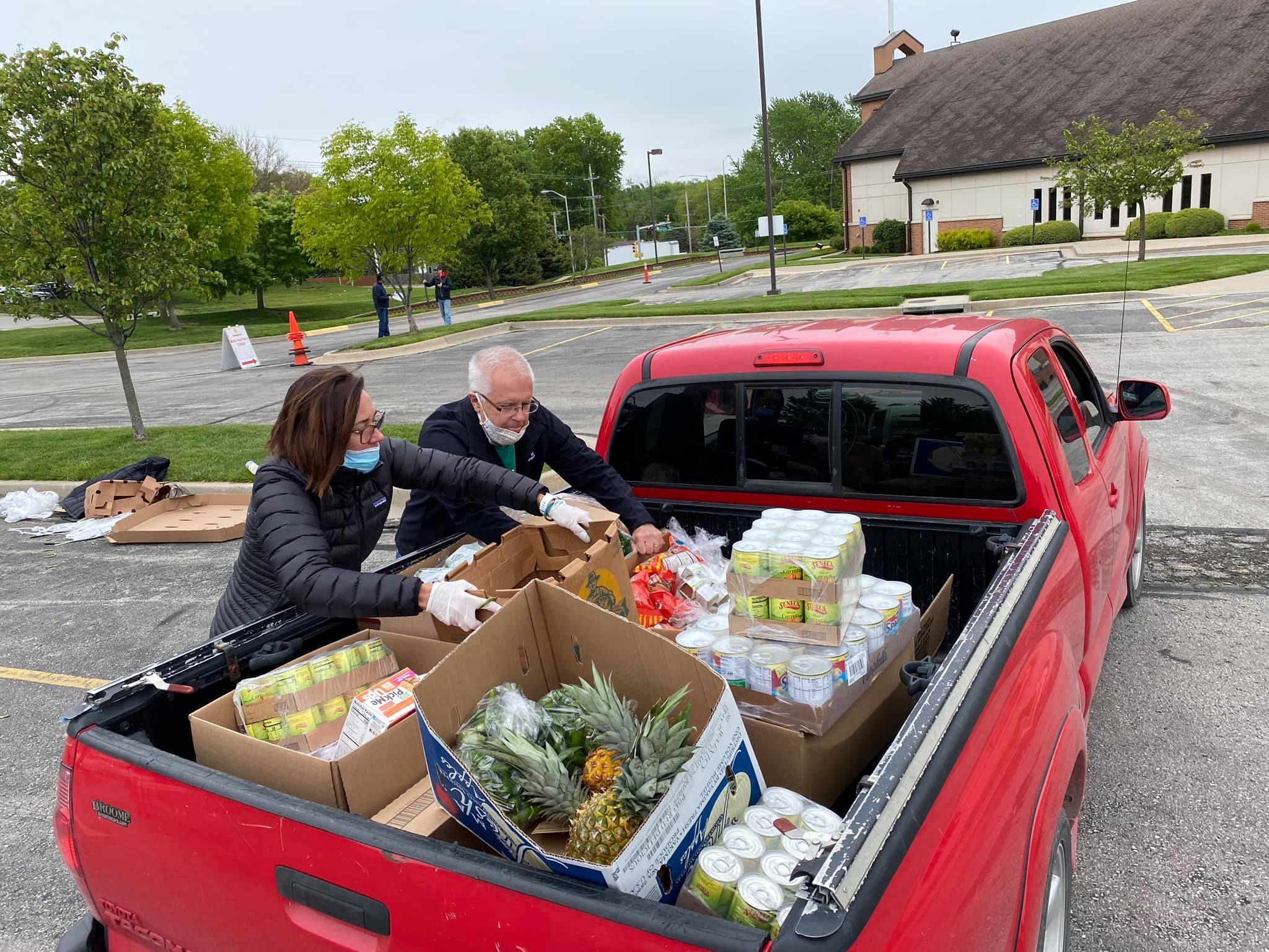 Renewed Hope volunteers transport food from a pickup truck to the pantry. 