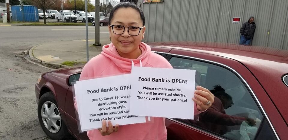 Tacoma, Washington, ACS food pantry volunteer gets ready to put signs up before drive-through operation begins. 