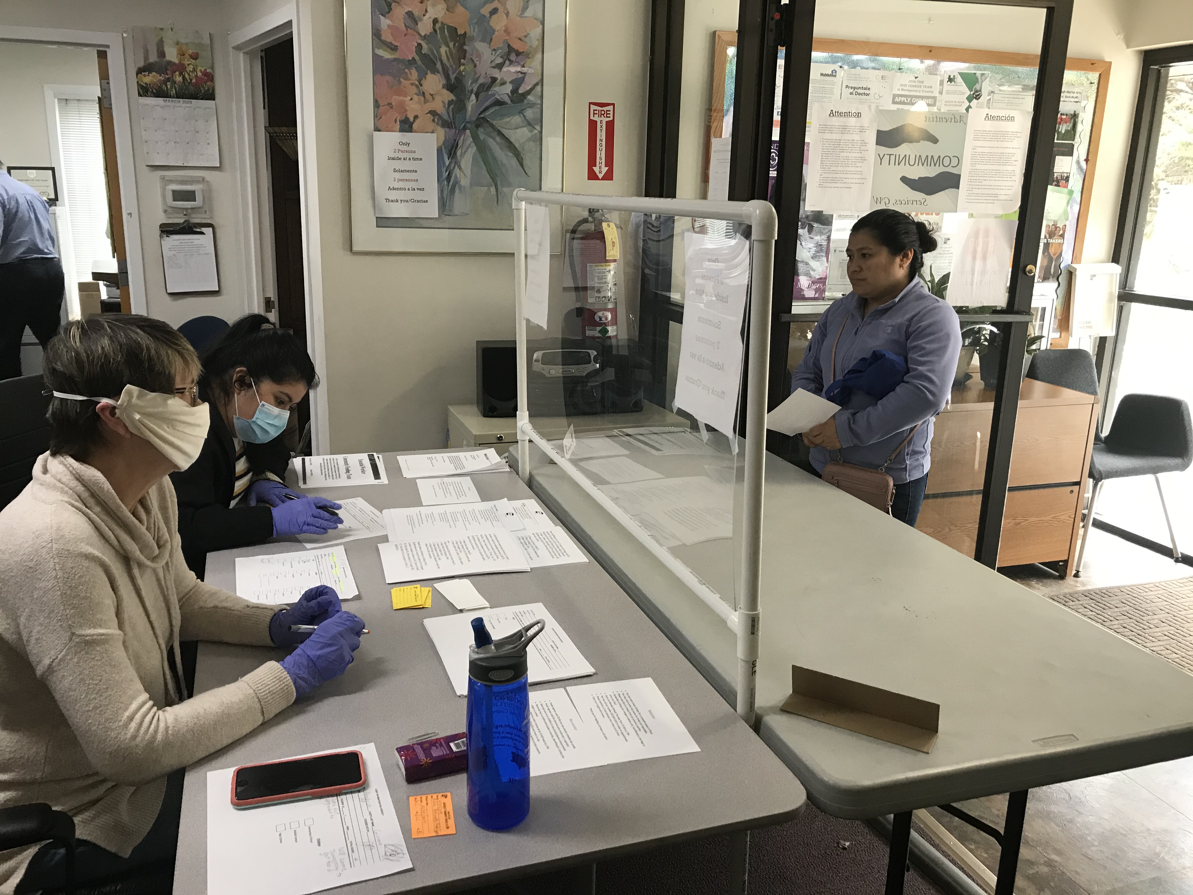 A client of Adventist Community Services Greater Washington checks in before collecting a food basket. Volunteers of ACSGW wear gloves and masks to help in an effort to do all they can to stop the spread of the coronavirus disease. 