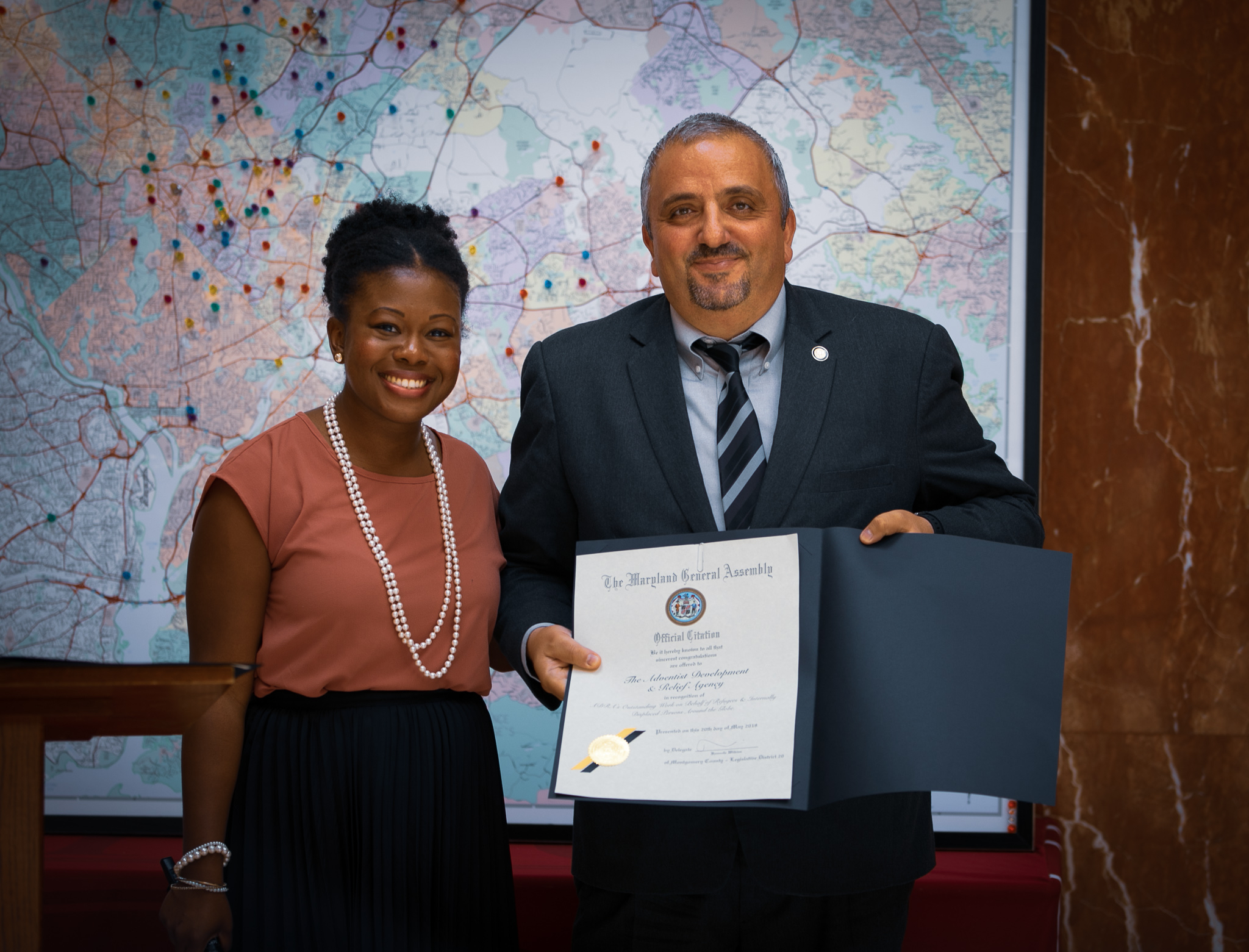 State assemblywoman Jheanelle Wilkins presents Imad Madanat, vice president for programs at ADRA International, with an official citation for ADRA’s refugee work from the state of Maryland.