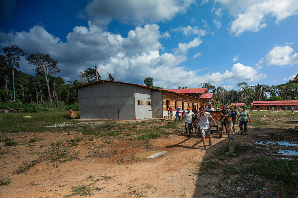 Students from Loma Linda University haul a collection of lose blocks away from the construction site. 