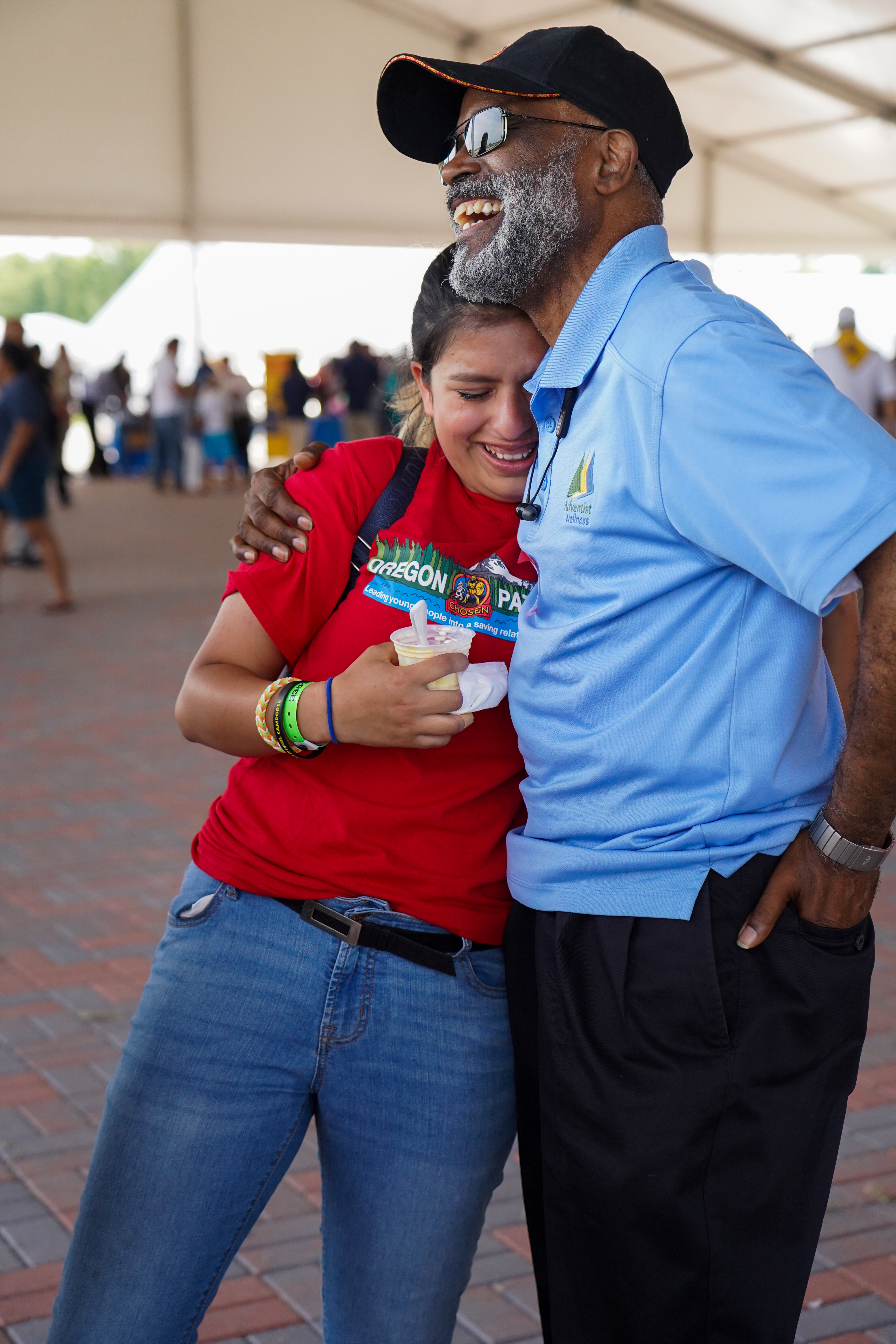 Byron Dulan, vice president for regional affairs of the North Pacific Union Conference, embraces Ashley Castro, a Pathfinder from the Oregon Conference, after she shares her desire to become pastor. 