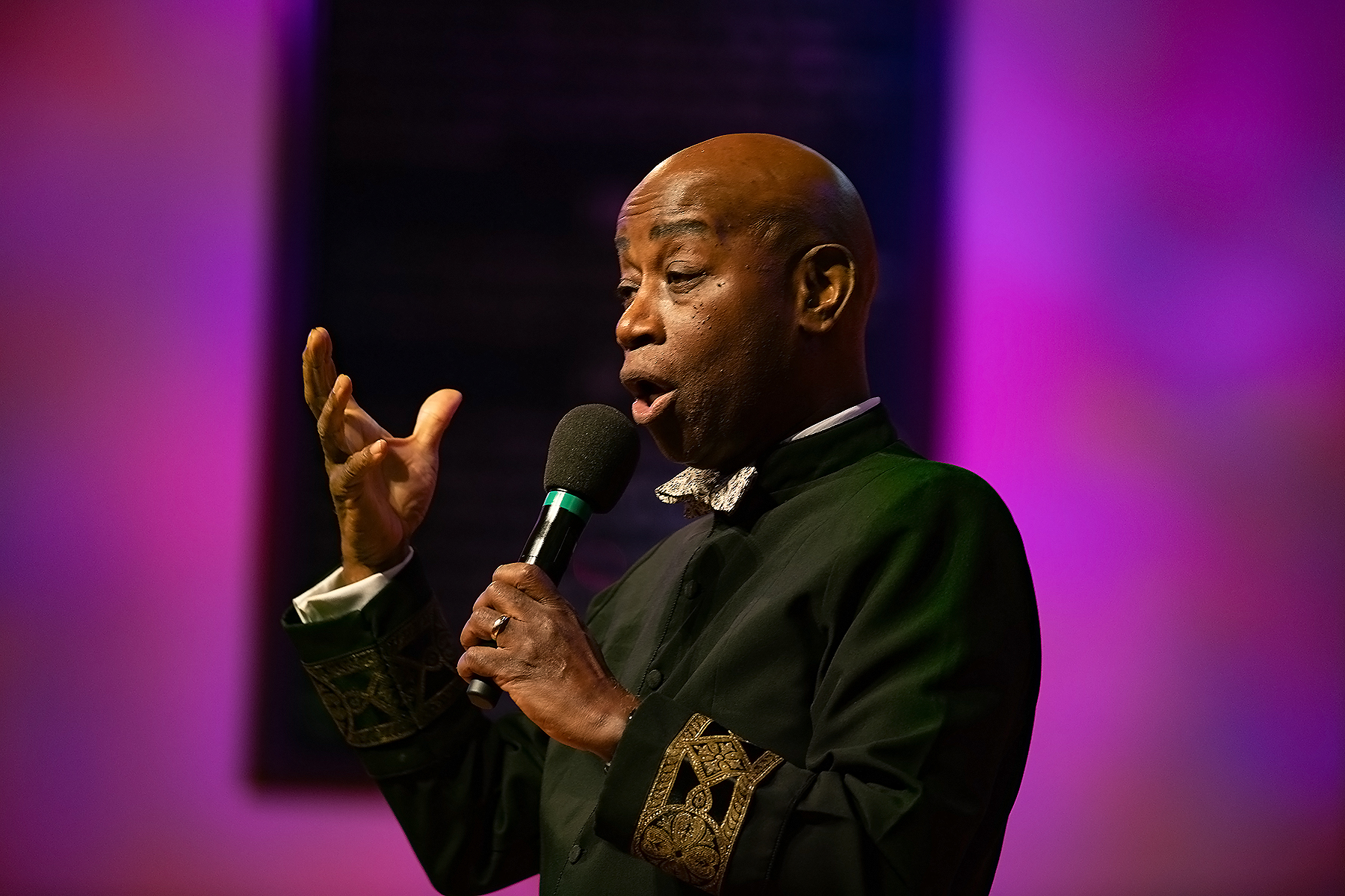 Black man holding a microphone, speaking