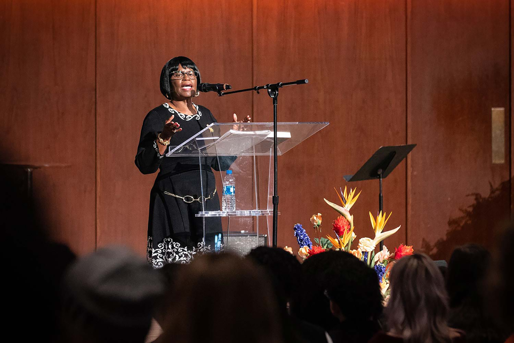 Sarah Collins Rudolph, survivor of 1963 Birmingham Church bombing, standing at a podium with a mic sharing her story in front of a crowd