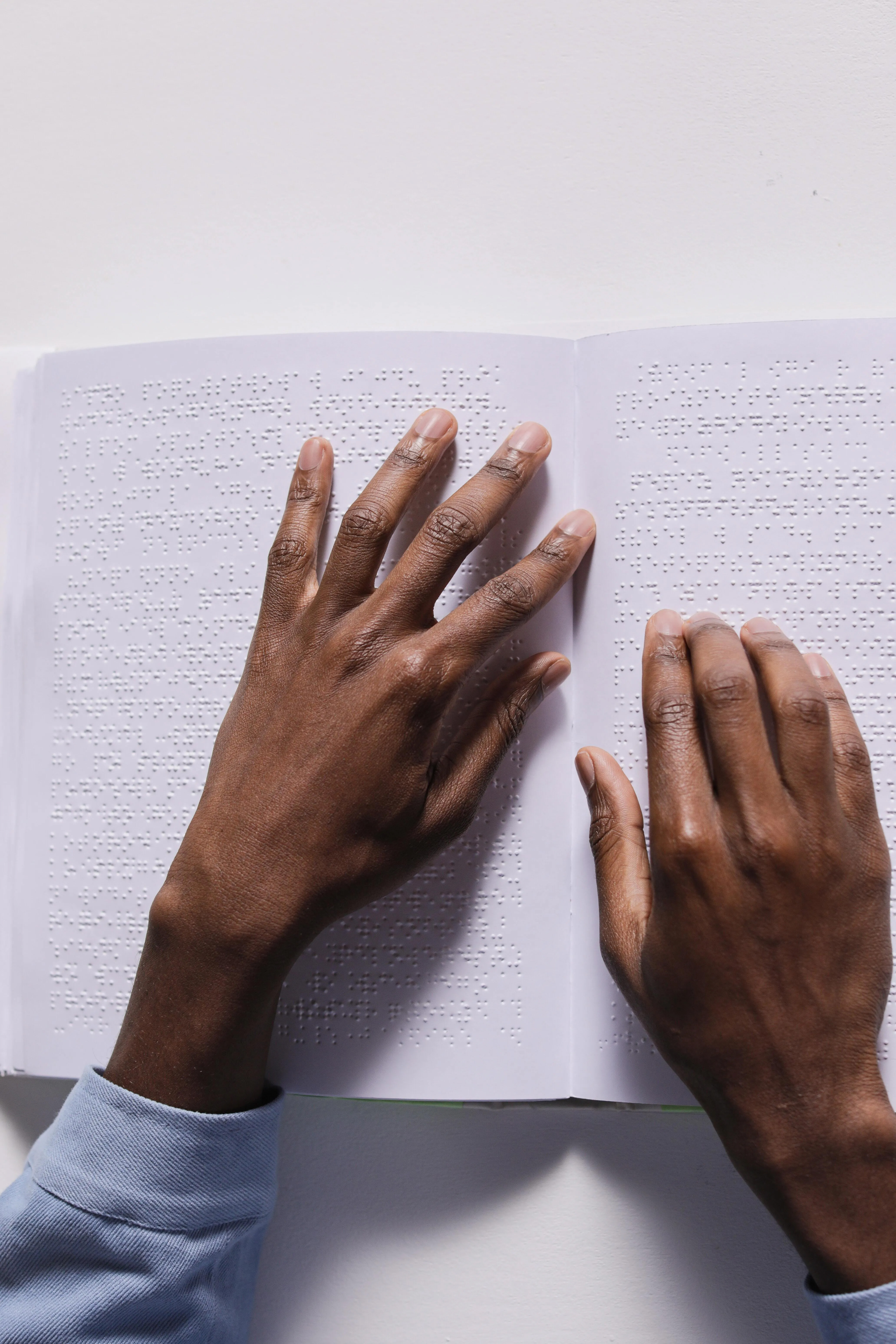 Brown hands reading braille