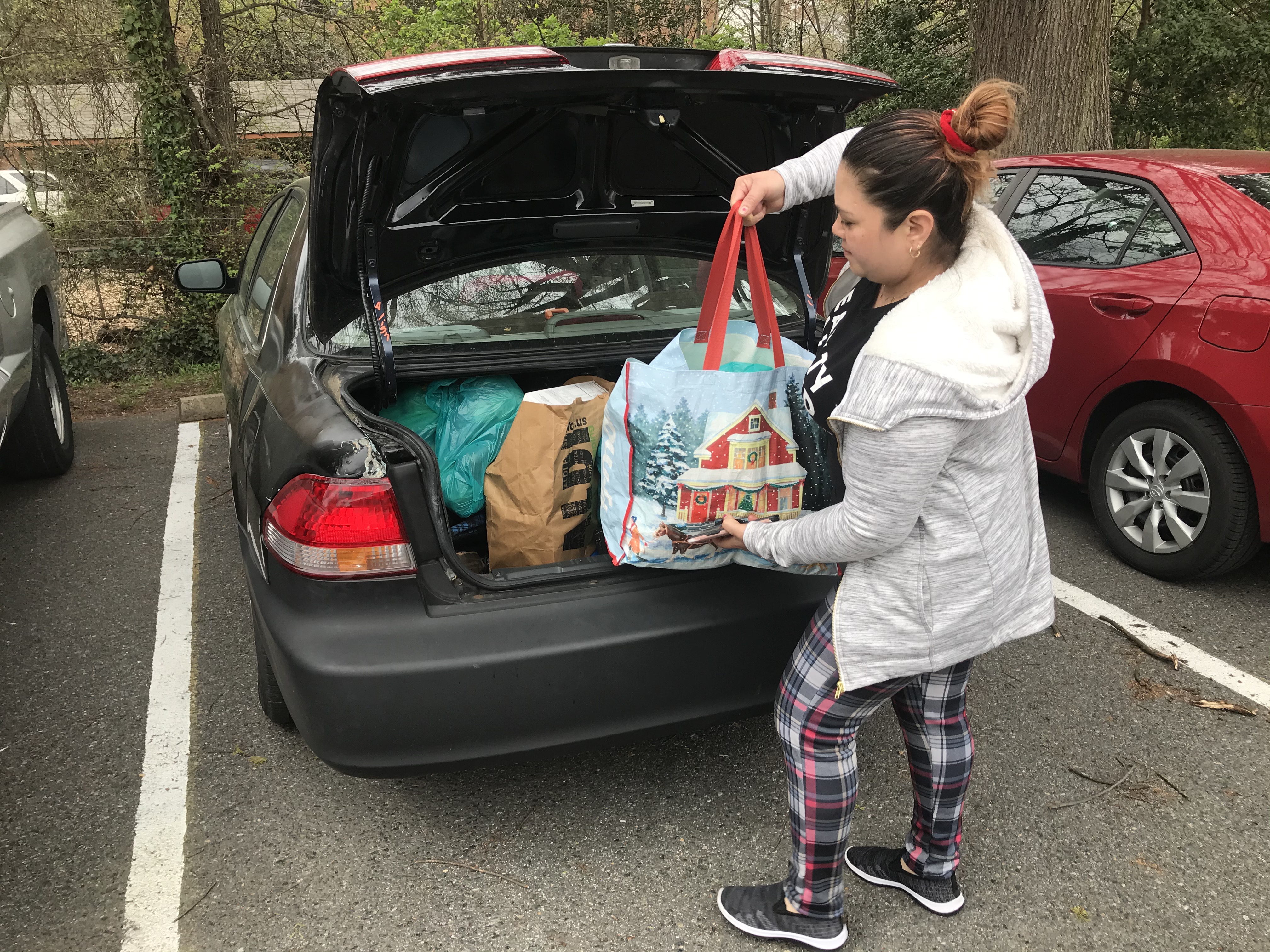A woman loads up her trunk with food from Adventist Community Services Greater Washington for three families. 