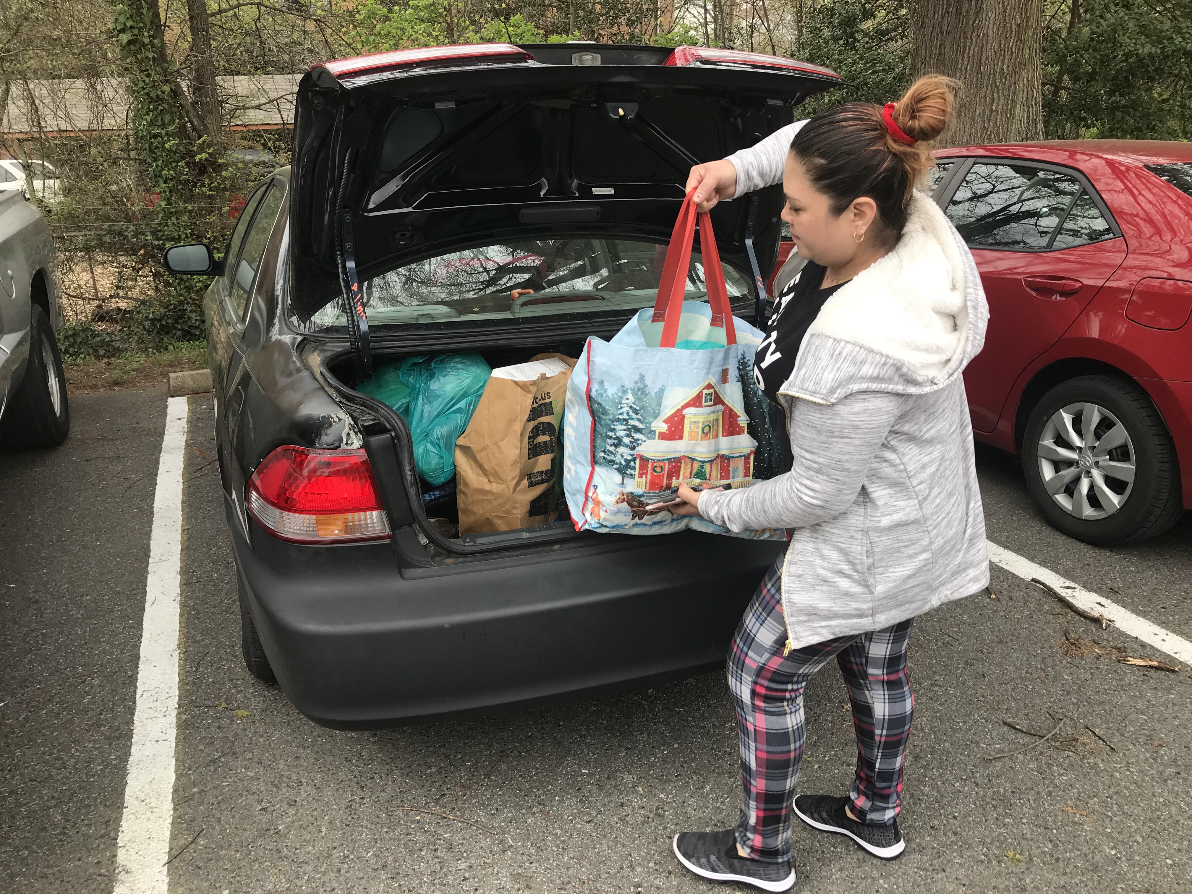 A woman loads up her trunk with food from Adventist Community Services Greater Washington for three families.
