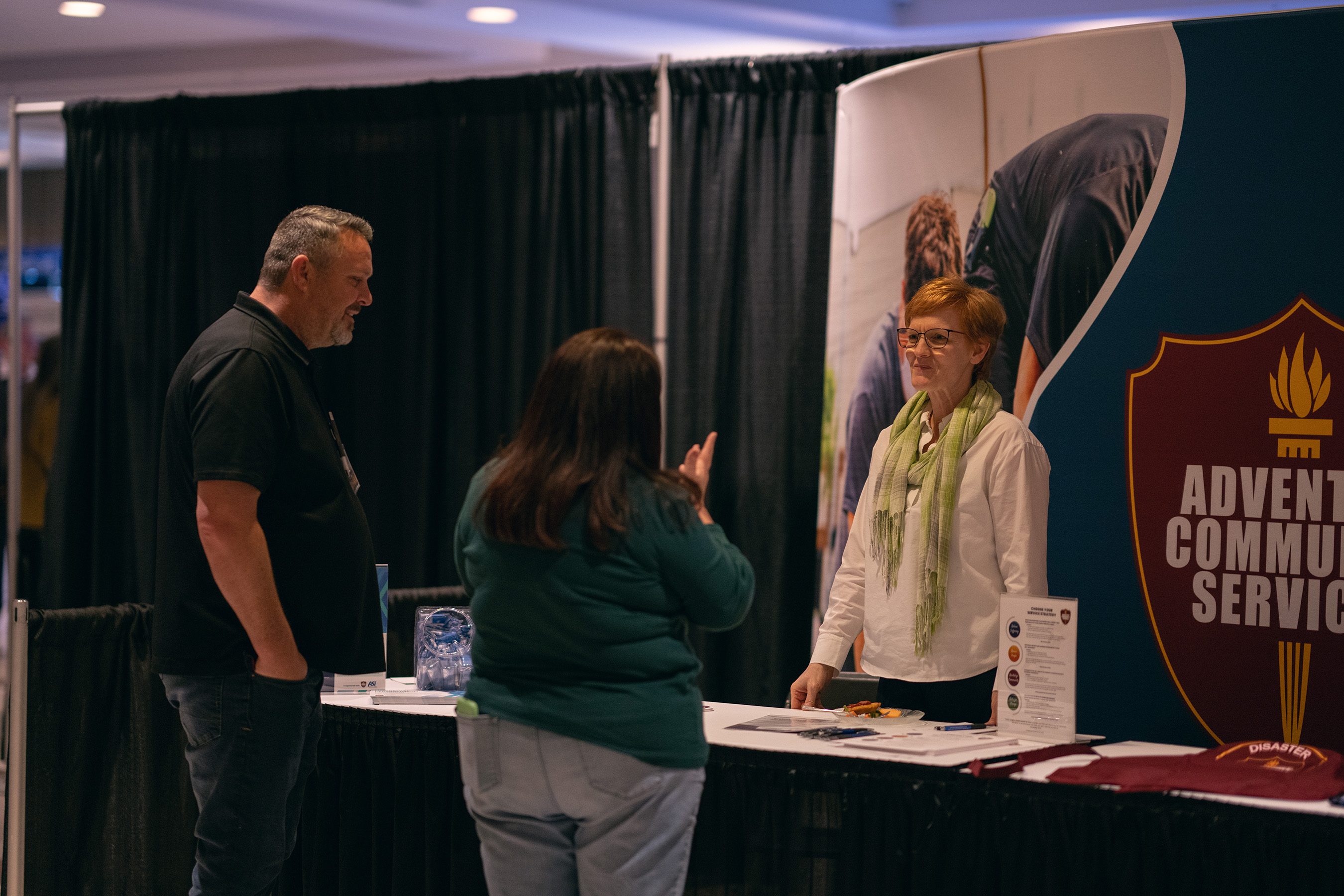 Colette Newer, North American Division (NAD) associate director, ACS, engages with visitors in the exhibit hall of the NAD's Adventist Ministries Convention