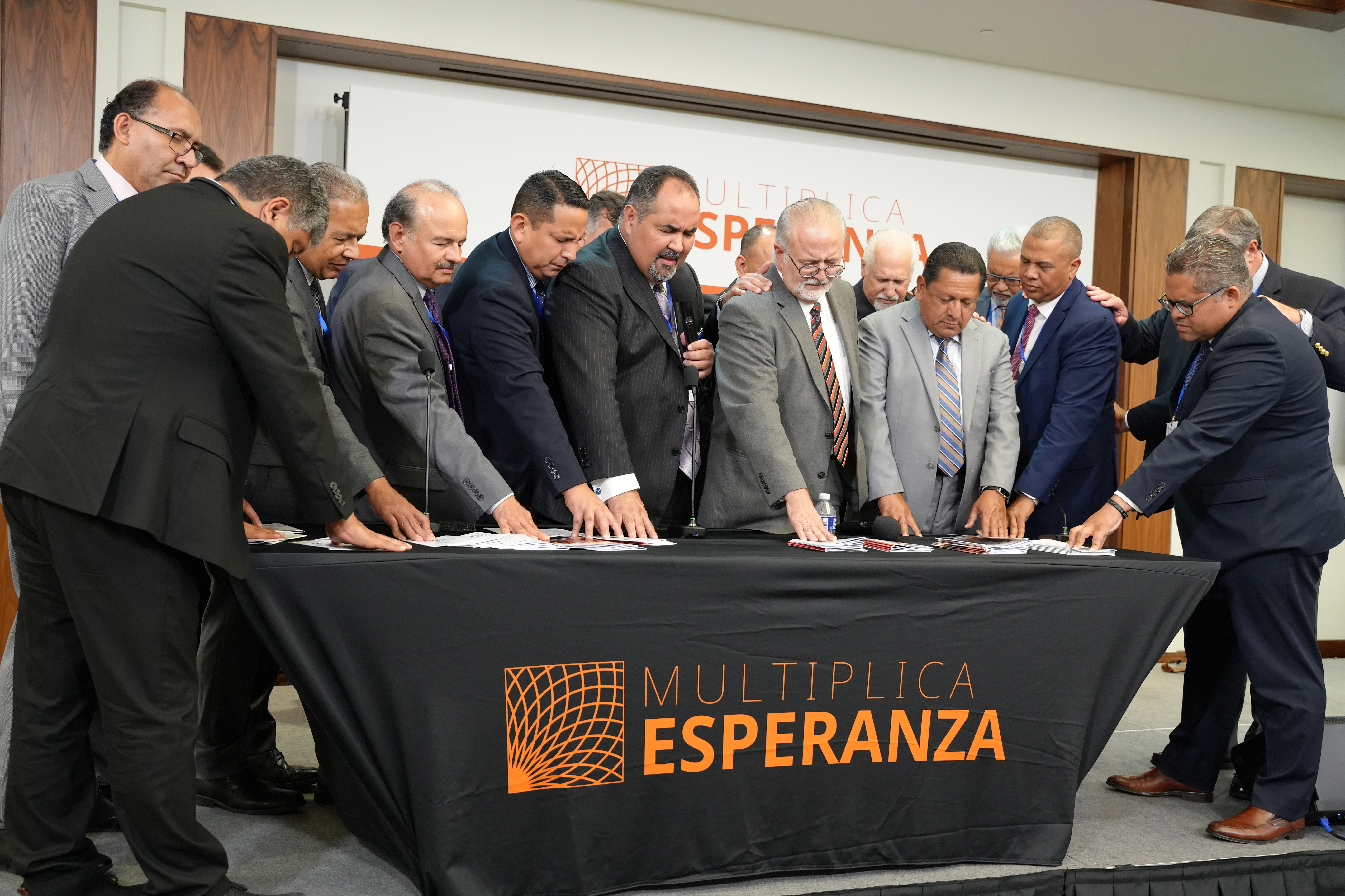 Caption: Pacific Press, Hispanic Ministries coordinators, and attendees pray for 2023 evangelistic literature. Photo by Magali Torres/NAD