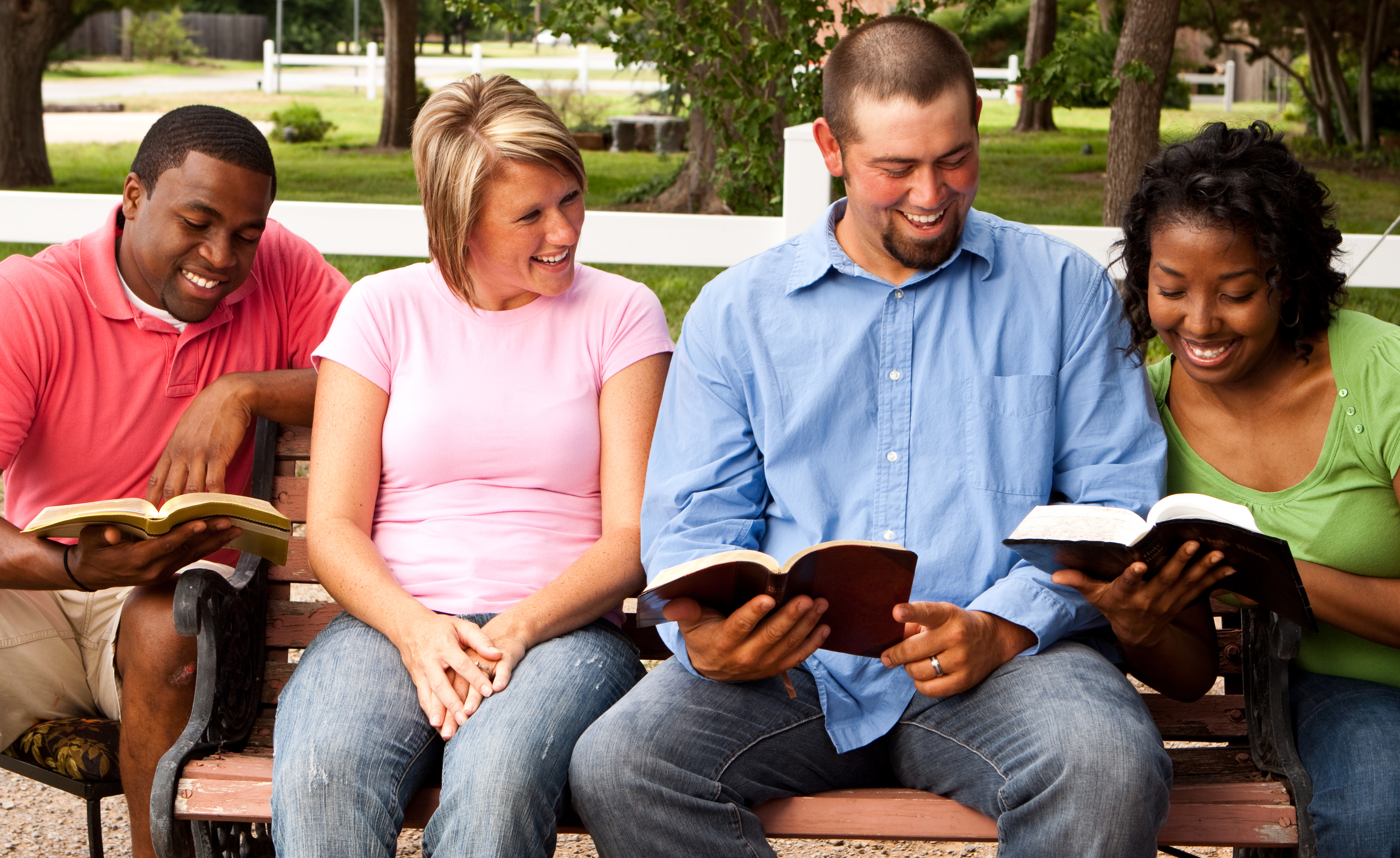 Getty images stock photo of four adults in Bible study on park bench