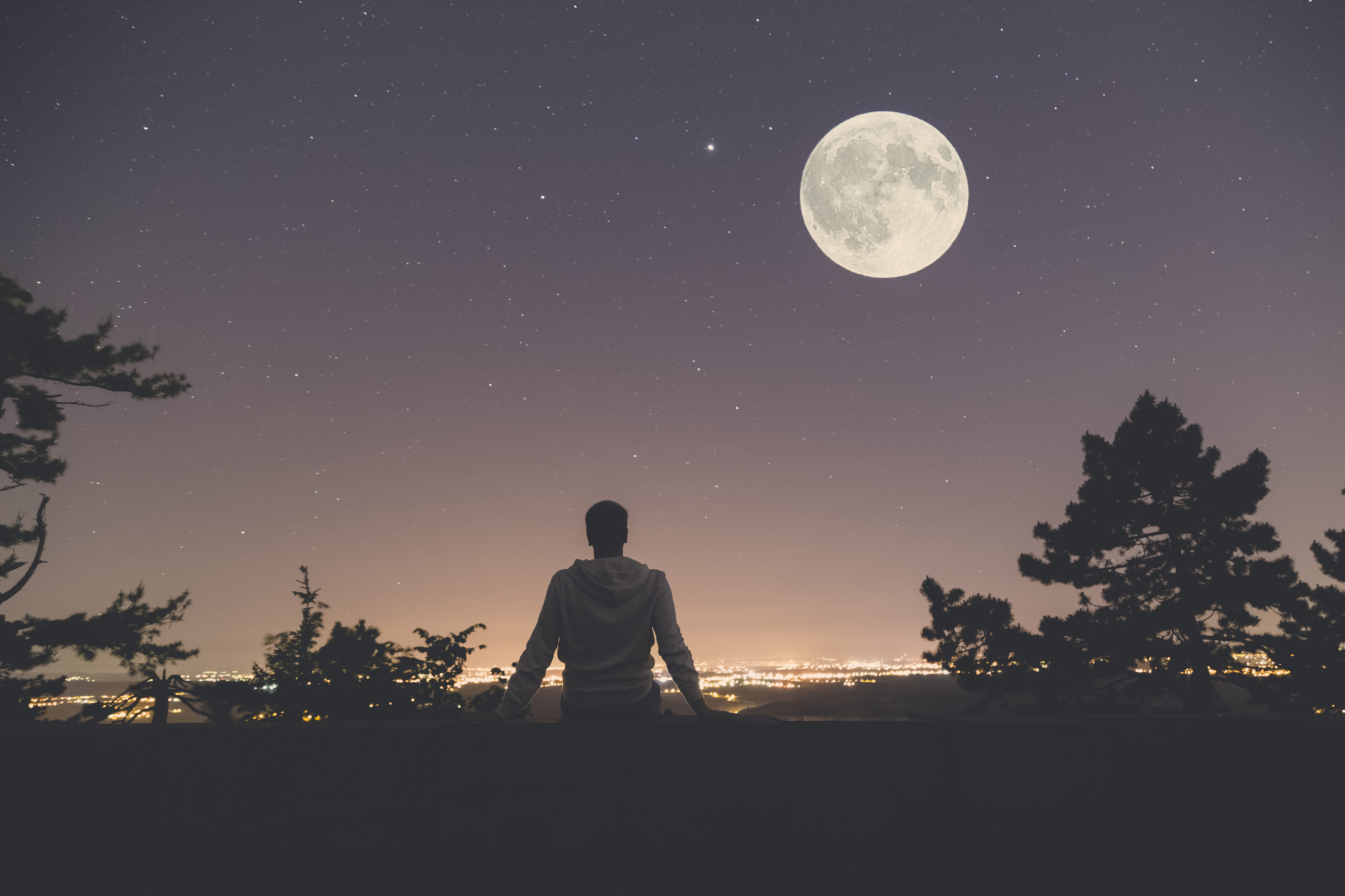 Stock photo of man looking at stars and moon