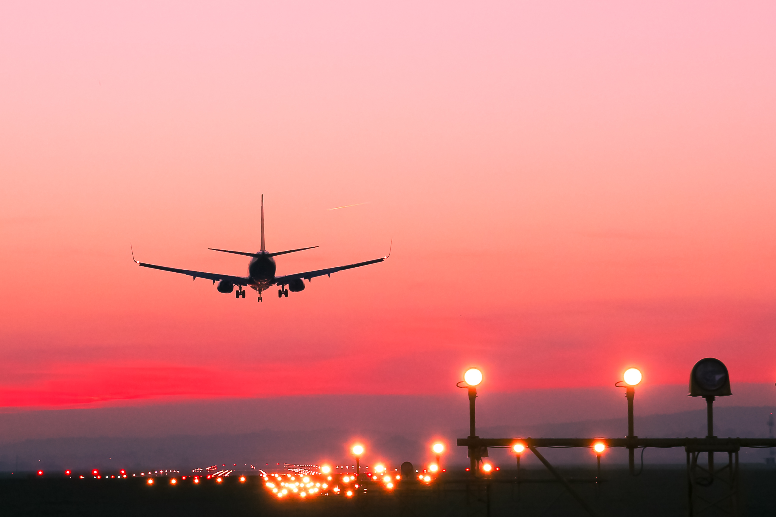 stock photo of airplane landing at sunset