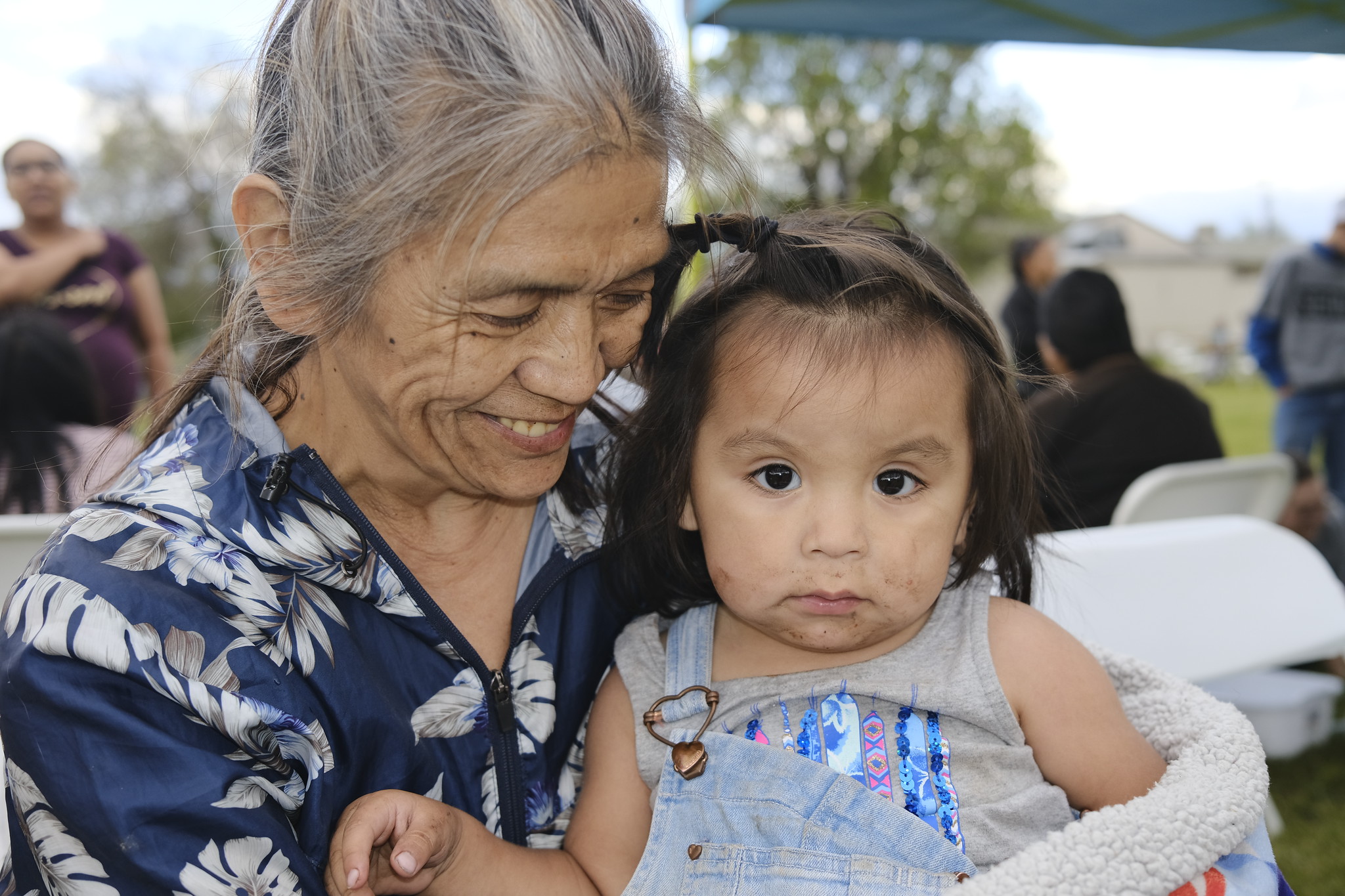 Tribal citizen Kimiko Danzuka Mitchell smiles while holding her granddaughter at the shoe giveaway event.