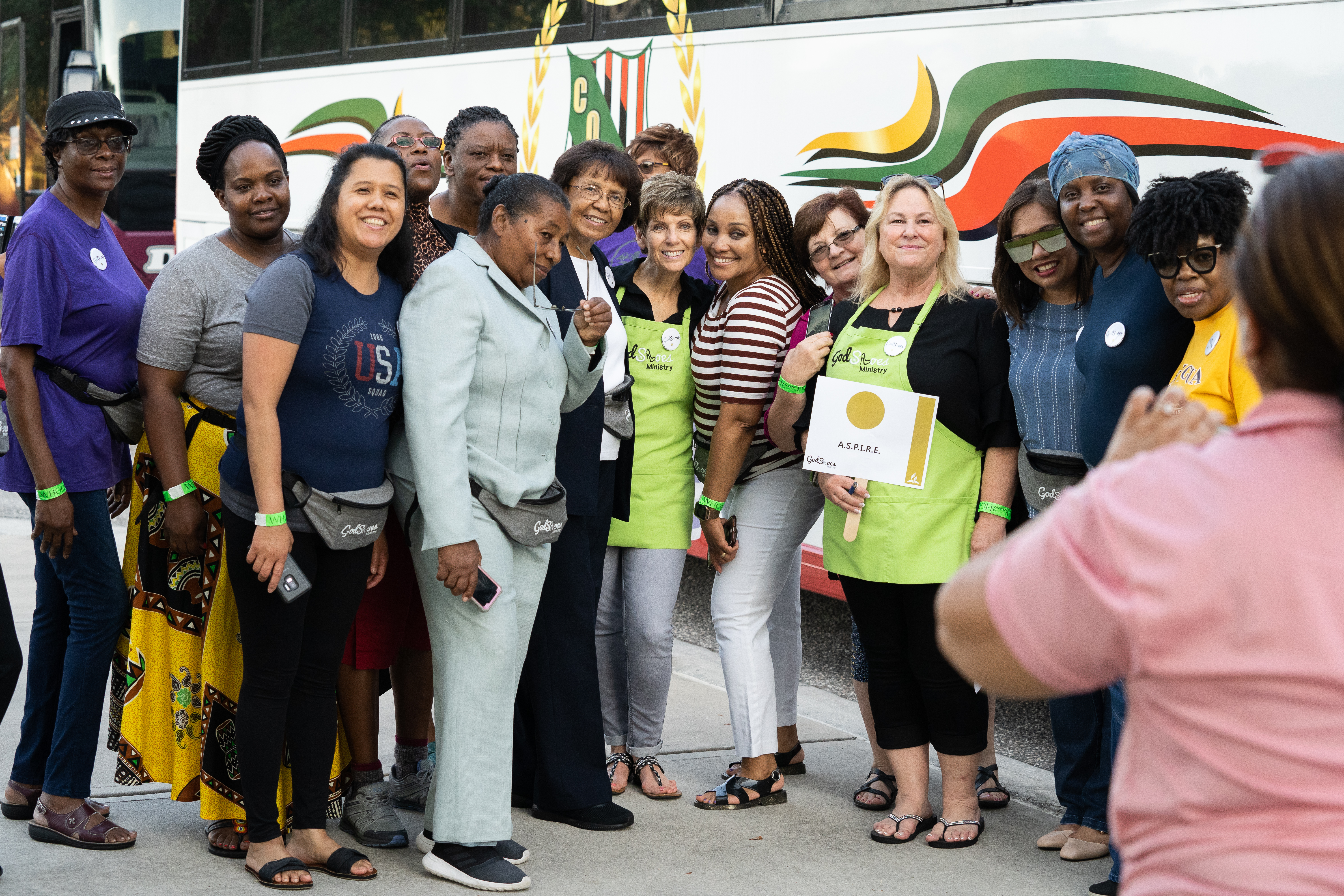 Jo Dubs (center), founder and director of God in Shoes, poses with a group of volunteers preparing to leave the convention center for their service assignment.