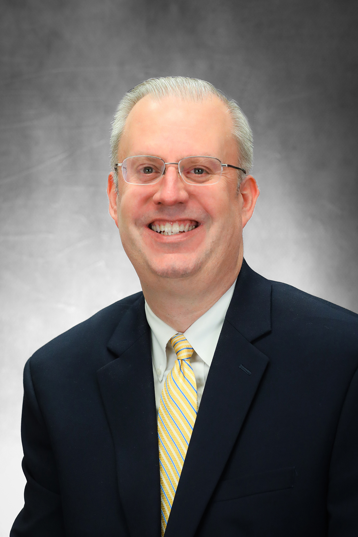 Smiling white man wearing glasses and a suit