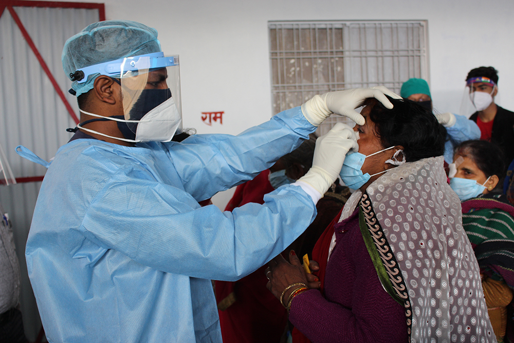 A member of the medical team cleans a woman’s eye in preparation for the surgery.