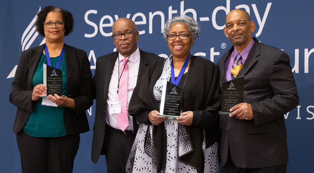 Left to right - Black woman with glass plaque, Black man with no plaque, Black woman and Black man, both with glass plaques