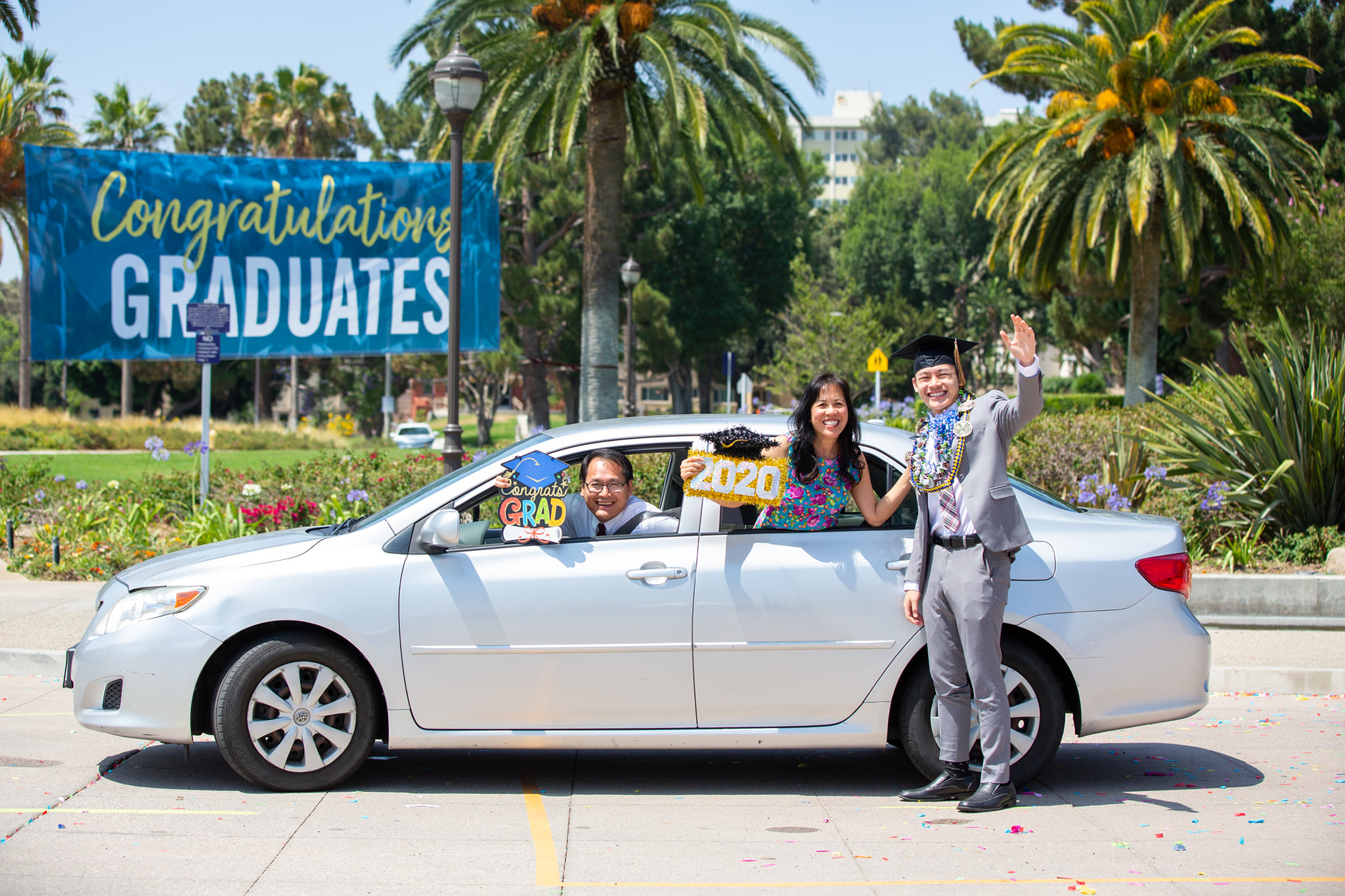 Pastor Vinh Nguyen, Cynthia Nguyen and their son and La Sierra graduate Timothy Nguyen stop near the central fountain at the top of Yaeger Drive for their portrait during La Sierra University’s Drive Through Celebration. 