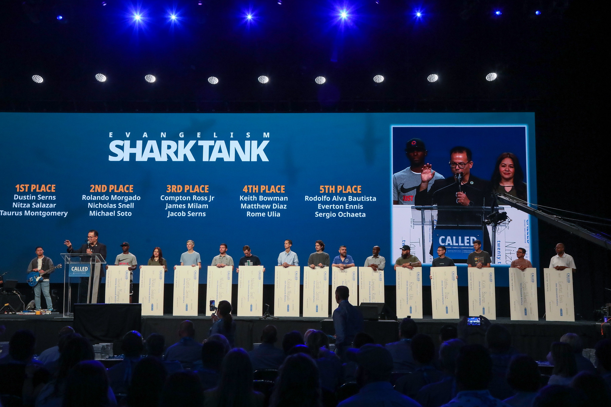 The fifteen evangelism shark tank finalists hold up their checks for a photo. Photo by: Heidi Baumgartner | North American Division