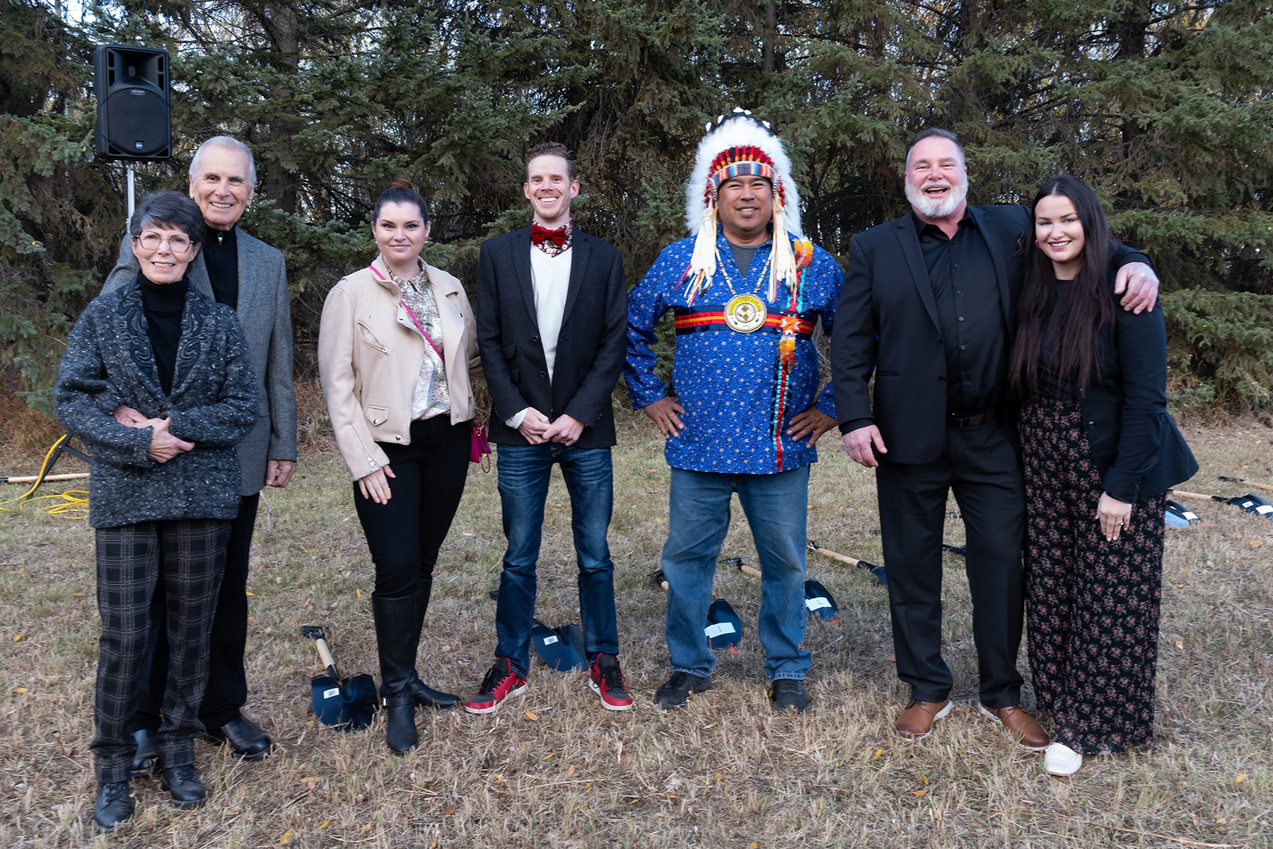 Several people standing on a patch of grass, including an Indigenous chief in costume.