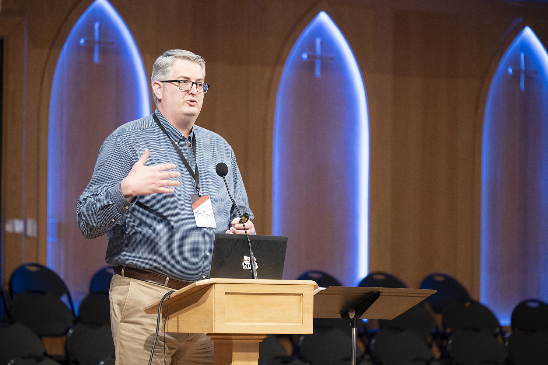 White man speaking from a podium in a church.